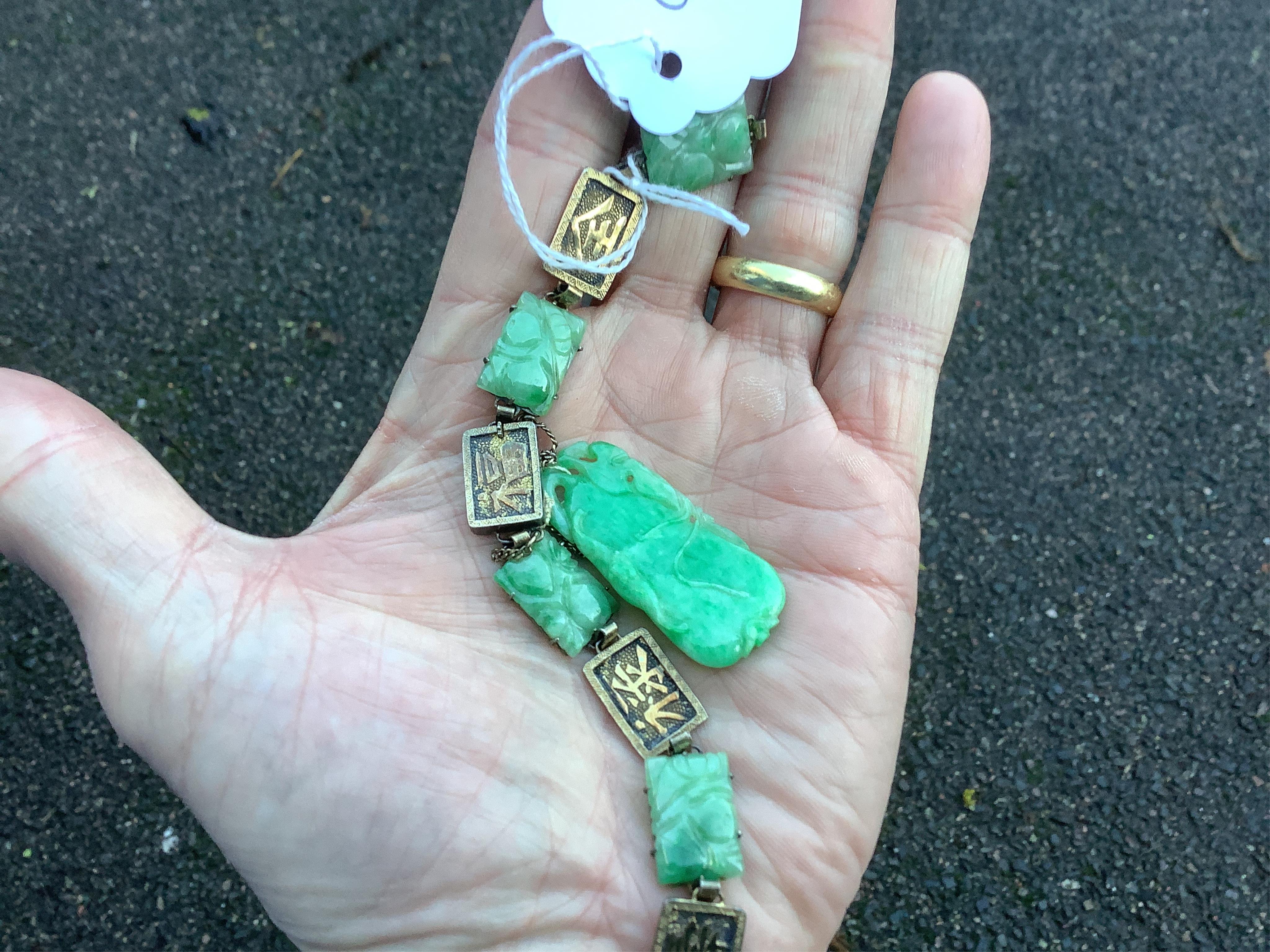 A Chinese gilt white metal and carved jade panel set bracelet, a.f, 17.5cm, together with a carved jade pendant, 40mm. Condition - poor to fair